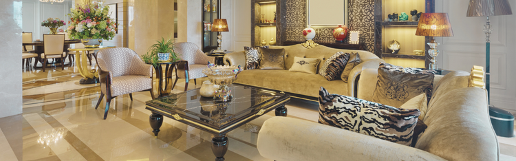 Luxurious living room with beige sofas, coffee table, and decorative items.